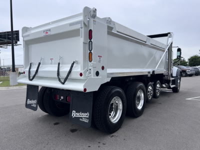 Mack GR64F dump truck rear three-quarter view showing dual rear tires, white dump body, rear tailgate and mud flaps with Brueckner’s logo.
