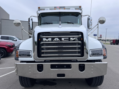 Mack GR64F dump truck front view showing large chrome grille with MAC K lettering, steel bumper with tow hooks, and wide headlights.