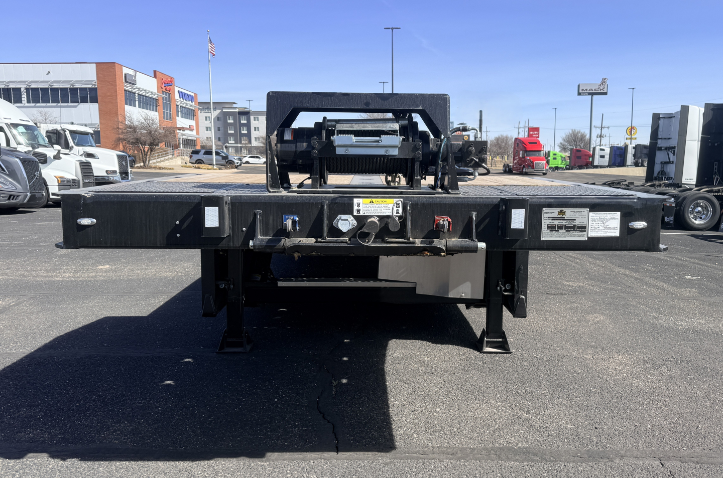 Landoll 440B-53 40-ton traveling axle lowboy trailer rear view showing deck with hitch, ramps, and markings.