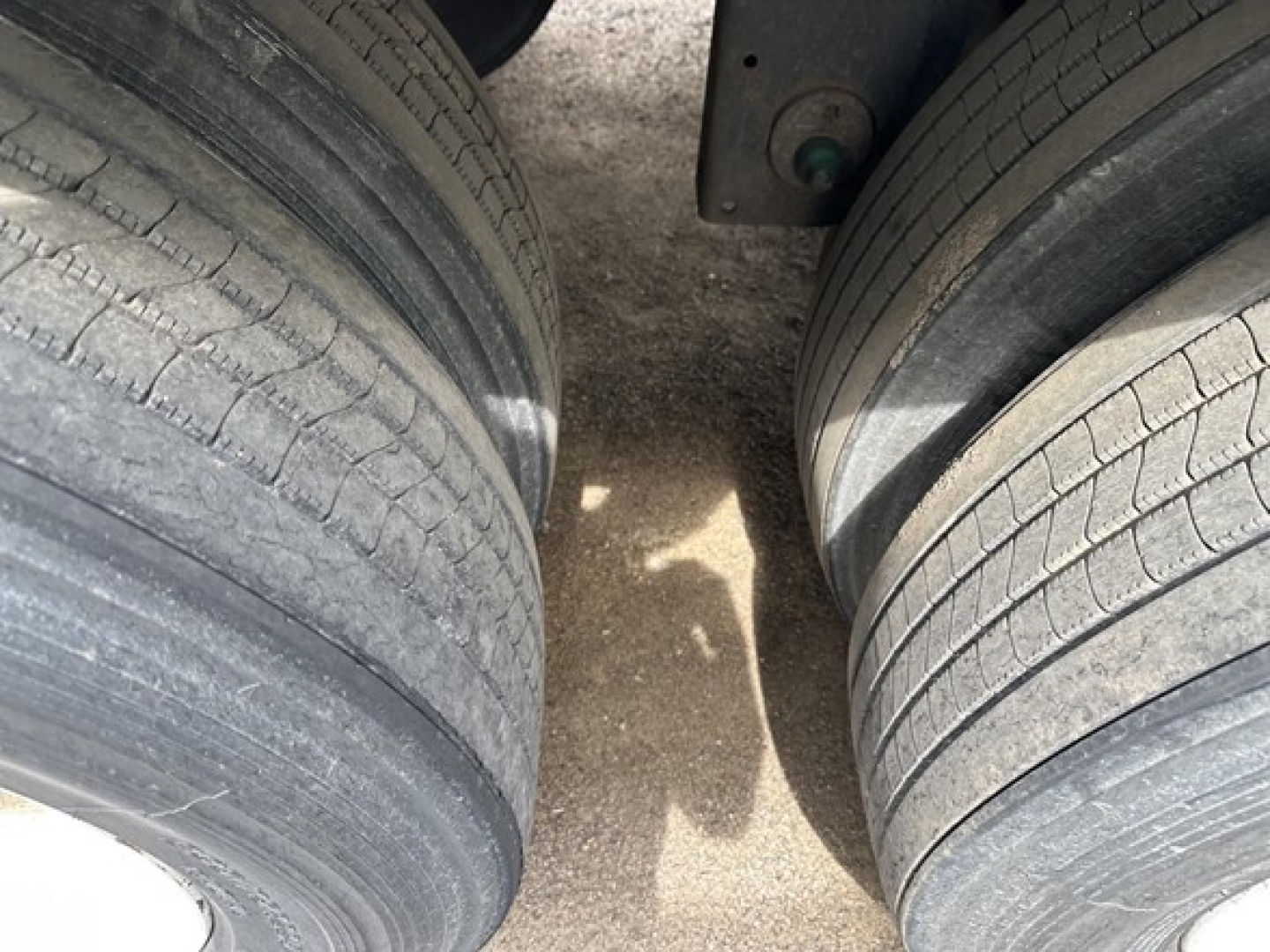 Dual rear trailer tires and undercarriage section of a 2016 Utility 4000D-X trailer showing exposed tire treads and gap between wheels.