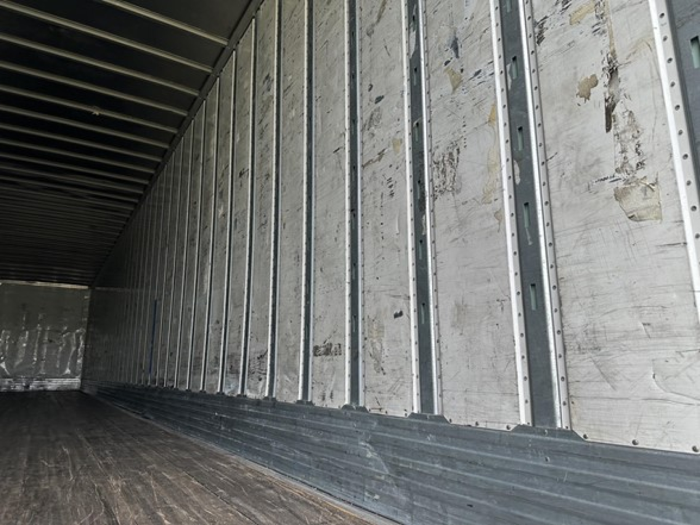 Trailer interior view showing metal side walls and wooden floor in a 2016 Utility 4000D-X trailer.