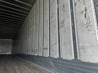 Trailer interior view showing metal side walls and wooden floor in a 2016 Utility 4000D-X trailer.
