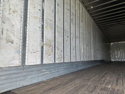 Trailer interior showing metal wall ribs and wooden floor with cargo van trailer walls and ceiling.