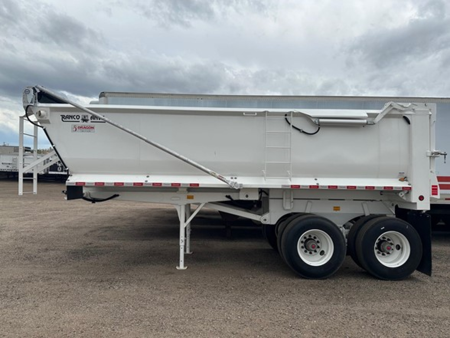 Ranco Elliptical Tub Quarter Frame Steel Rock End Dump trailer showing side view with wheelset and support leg.