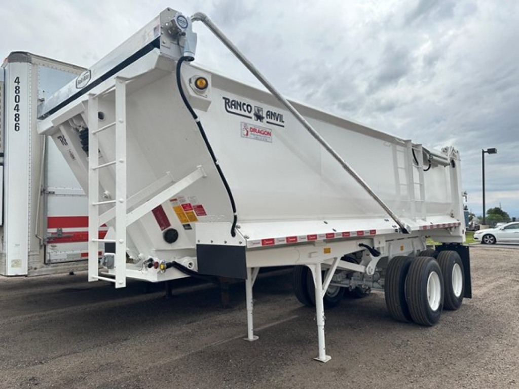 Dump trailer showing Ranco ANVIL logo, white steel frame, quarter-frame, dual rear axles, side storage and landing legs.