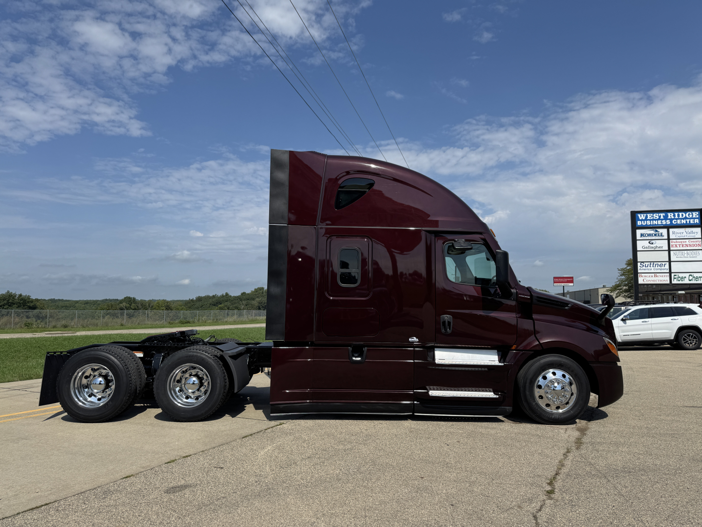 Tractor-trailer truck cab in side profile showing Freightliner Cascadia 126 with maroon paint and sleeper cab.