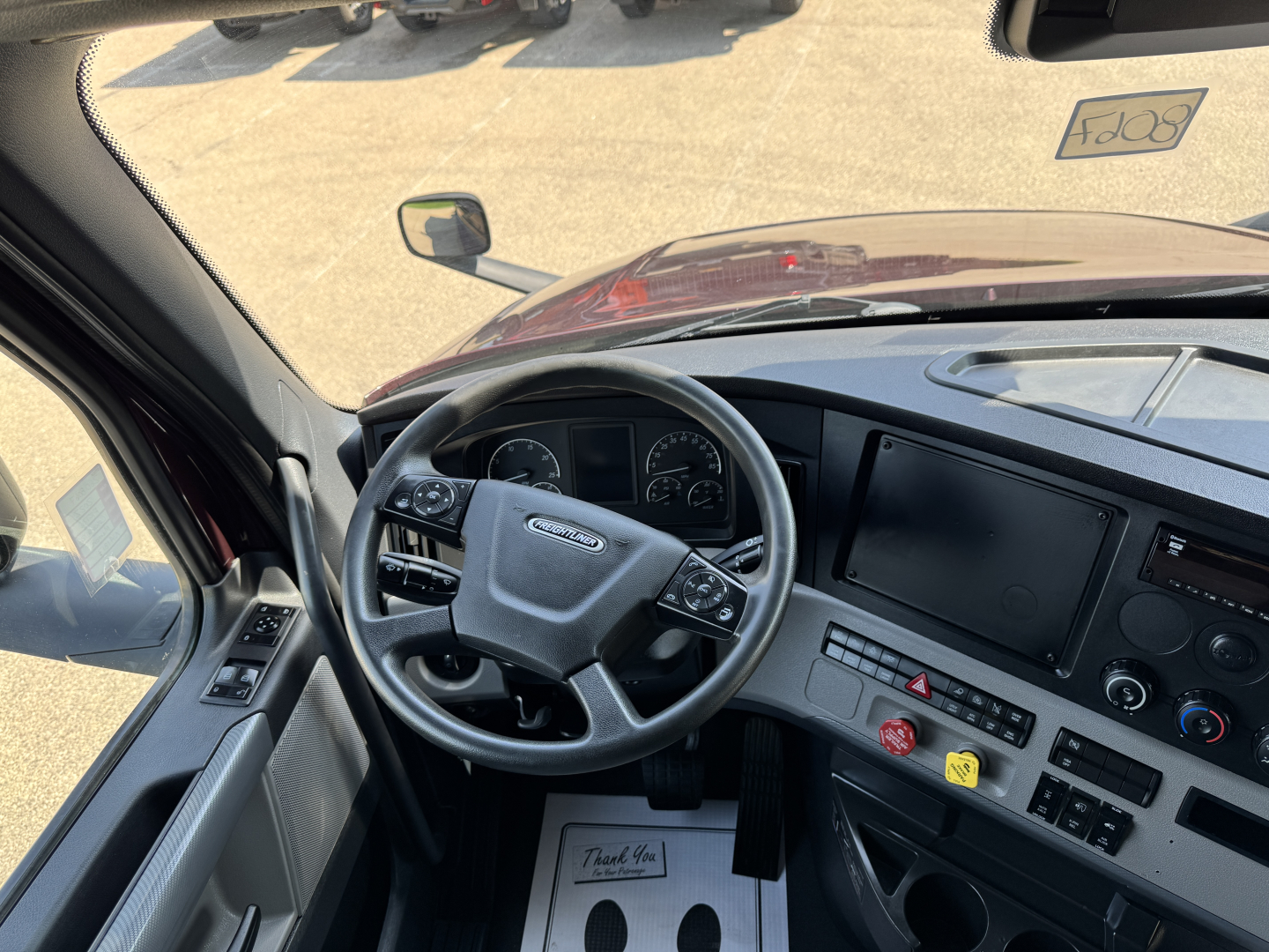 Cab interior of a 2022 Freightliner Cascadia 126 showing steering wheel, dashboard, and control panel.