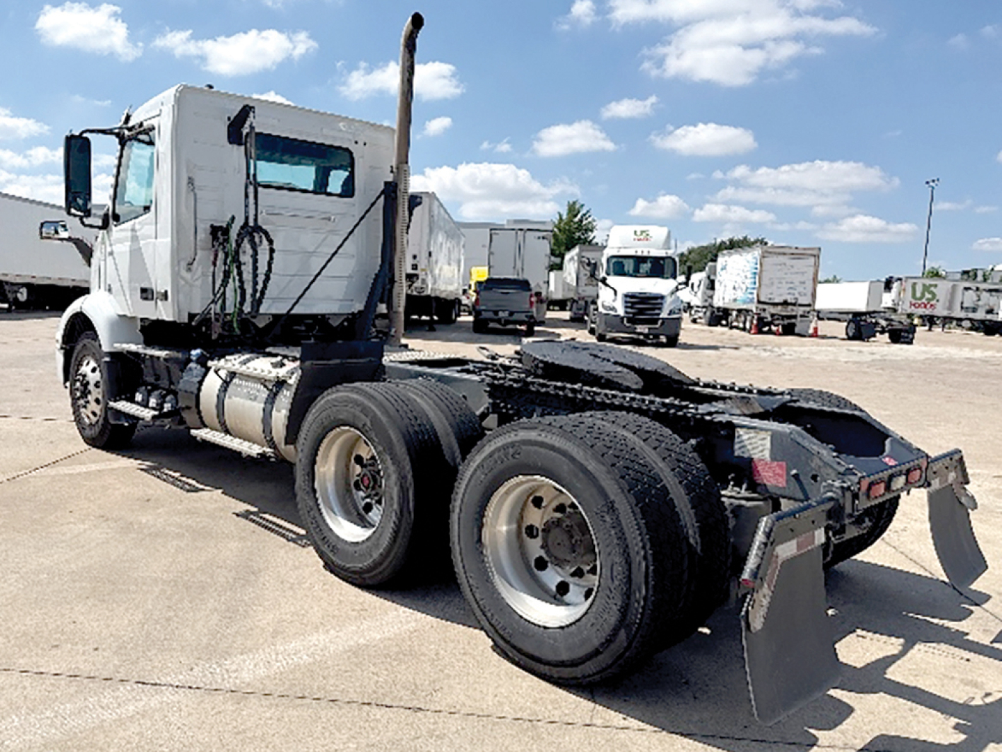 Volvo VNR 300 cab-forward truck chassis visible from rear left side showing dual rear axles and fifth-wheel plate.
