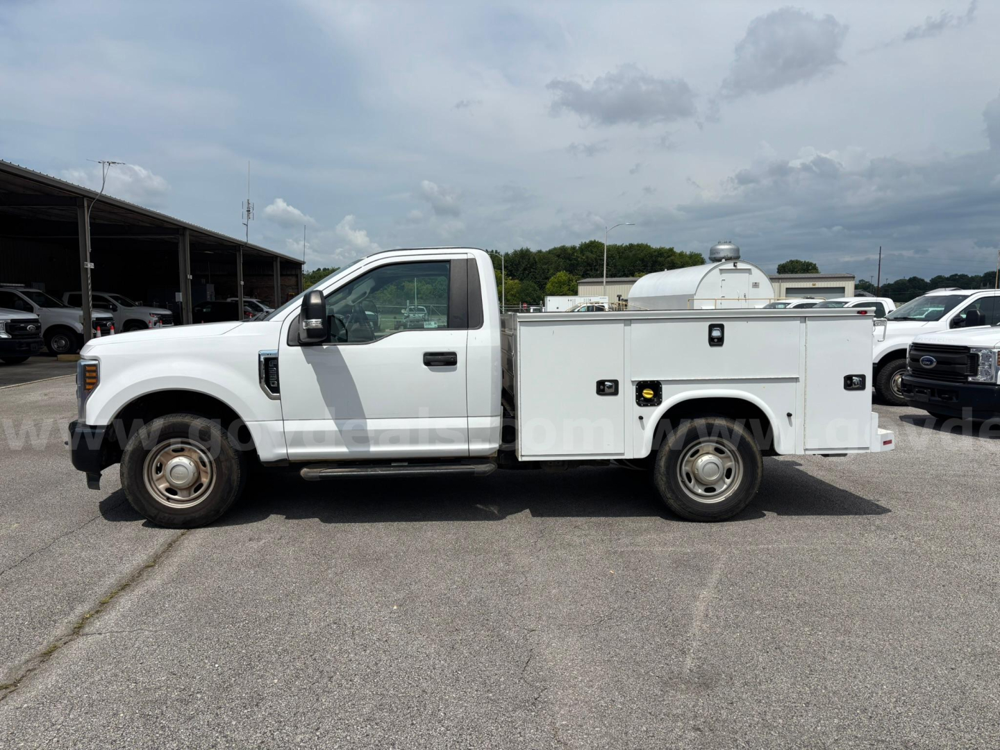 Ford F-250 utility/service truck side view showing utility bed with compartments and work light, 2019 model.