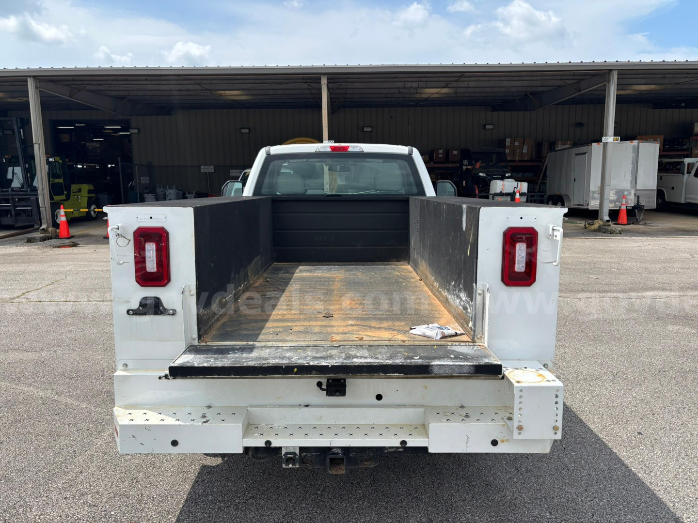 Ford F-250 bed with flat open cargo area and rectangular taillights, rear view showing empty pickup bed and hitch, service/utility truck.