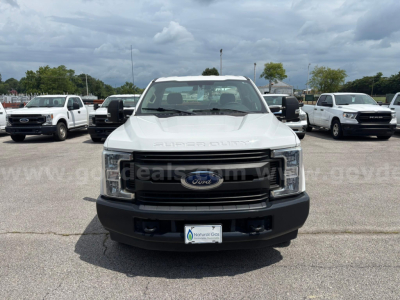 Ford F-250 Super Duty front view showing grille and Ford emblem in white truck, service/utility category used vehicle.