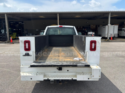 Ford F-250 bed with flat open cargo area and rectangular taillights, rear view showing empty pickup bed and hitch, service/utility truck.