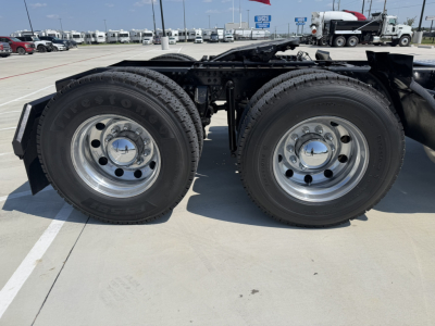 Dual rear wheels of a 2020 Mack PI64T truck chassis showing dual tires and chrome hubcaps with mounted rims.