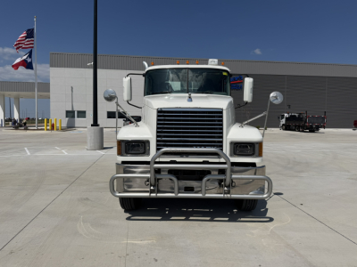 Front view of a white 2020 Mack PI64T conventional daycab truck with chrome bumper and grille, in a parking lot.