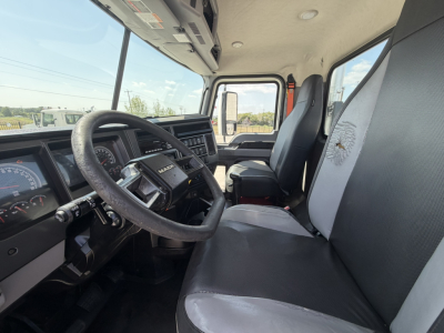 Cab interior of a 2020 Mack PI64T conventional daycab showing steering wheel, dashboard, and driver seat with light and gray upholstery.
