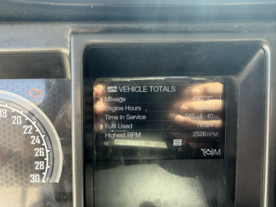 Dashboard instrument cluster and vehicle totals screen on a Mack truck showing Mileage, Engine Hours, Time in Service, Fuel Used, Highest RPM.