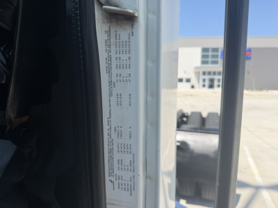 Vehicle VIN label visible on door frame with service and specification data in small text.