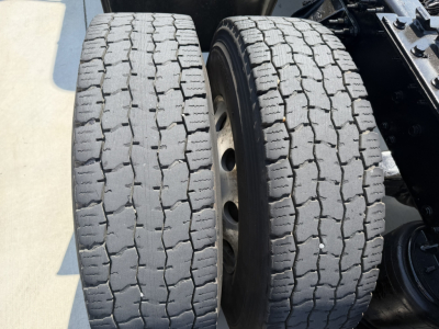 Twin rear truck tires on a Mack PI64T, showing tread pattern and rims.