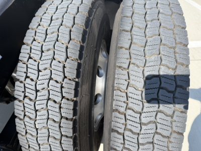 Twin rear truck tires on a Mack PI64T showing treads and wheel rims