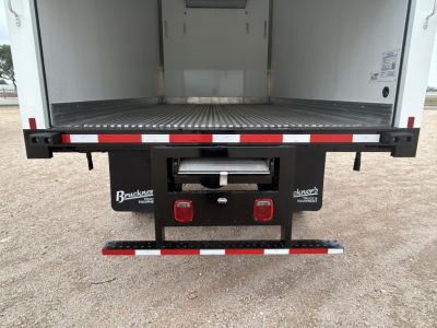 Mack MD6 refrigerated truck rear view showing open cargo area and rear bumper with taillights and reflectors.
