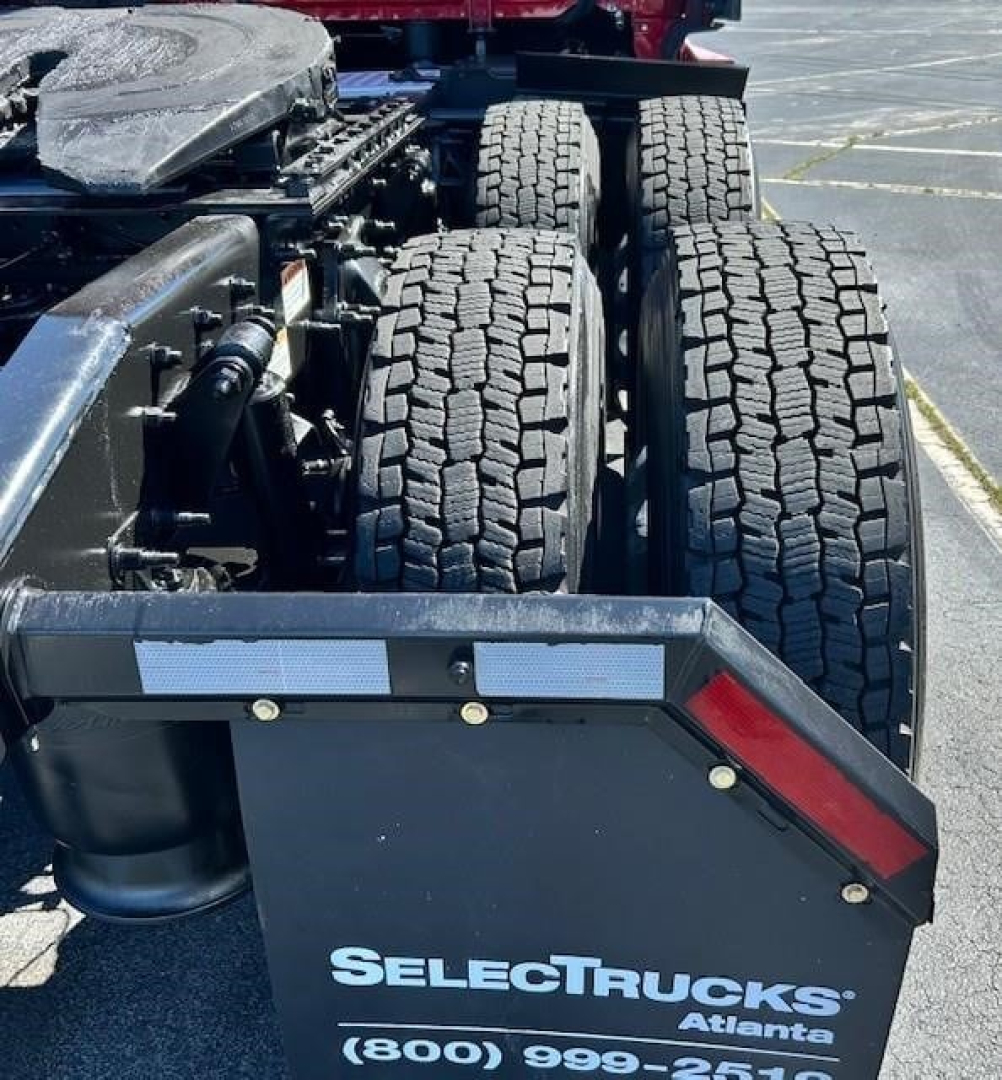 Tractor trailer rear view showing twin rear axles and chassis components on Freightliner Cascadia 126 with SelectTrucks Atlanta branding on mudguard.