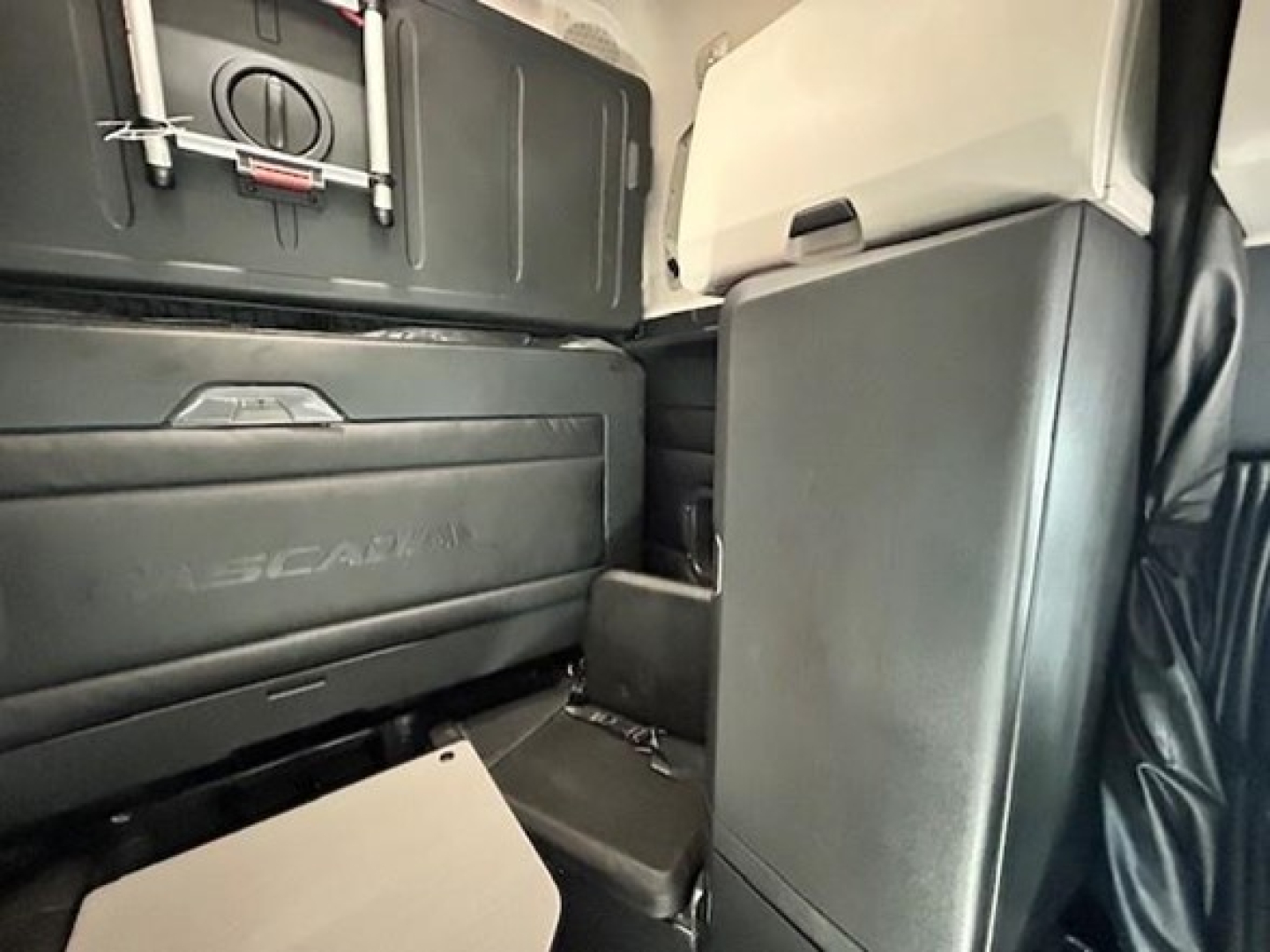 Truck cab interior showing storage compartments and seating area with a visible Freightliner/Western Star style dash panel.