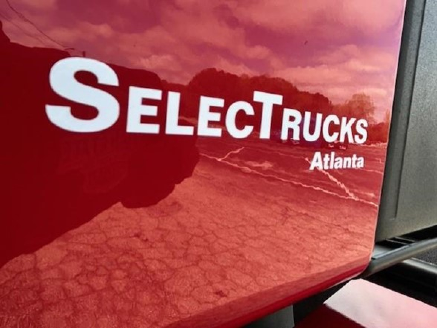 Selective Trucks logo on red Freightliner Cascadia 126 sleeper cab showing exterior branding.