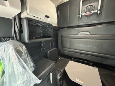 Cab interior of a 2023 Freightliner Cascadia 126 showing sleeper area and storage compartments.