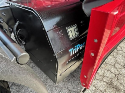 Truck interior components visible with black Toolbox labeled ‘Tripac Volvo’ near a red truck door in the foreground.