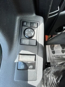 Truck interior control panel showing window/mirror adjustment buttons in a Freightliner Cascadia overhead console area.