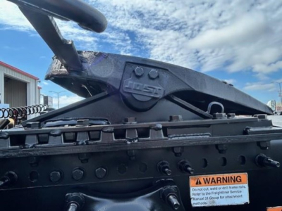 Hitch assembly and mounting frame with warning sticker visible in foreground of truck/tractor equipment.