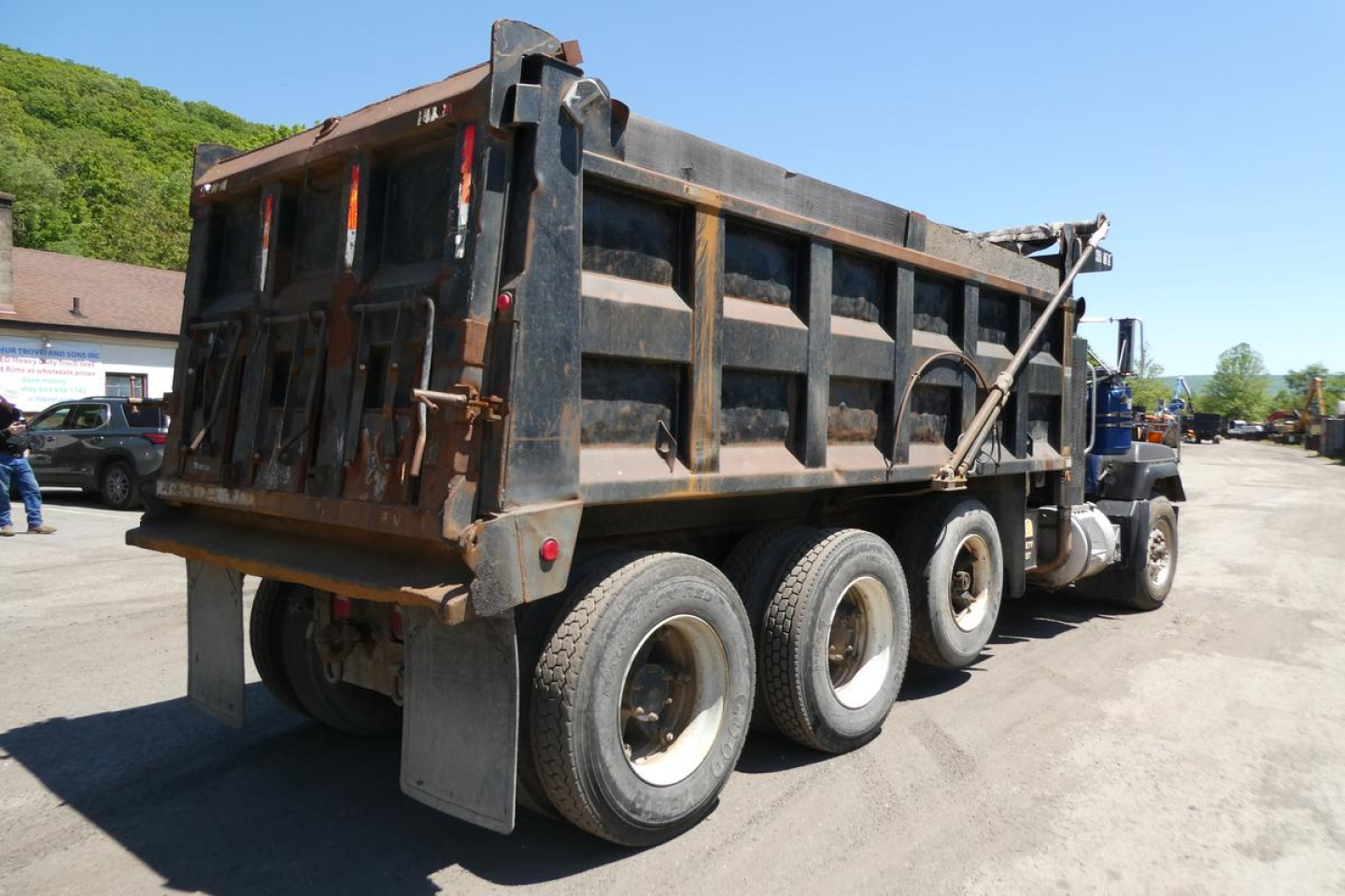Dump truck bed of a Mack RD688S showing side panels and rear load bed with tires and chassis.
