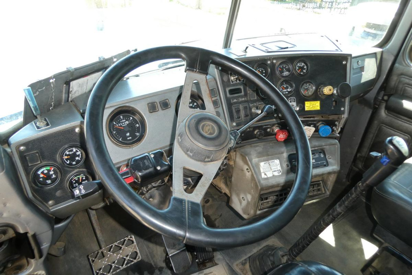 Interior of a Mack RD688S dump truck showing steering wheel and dashboard with gauges and controls.