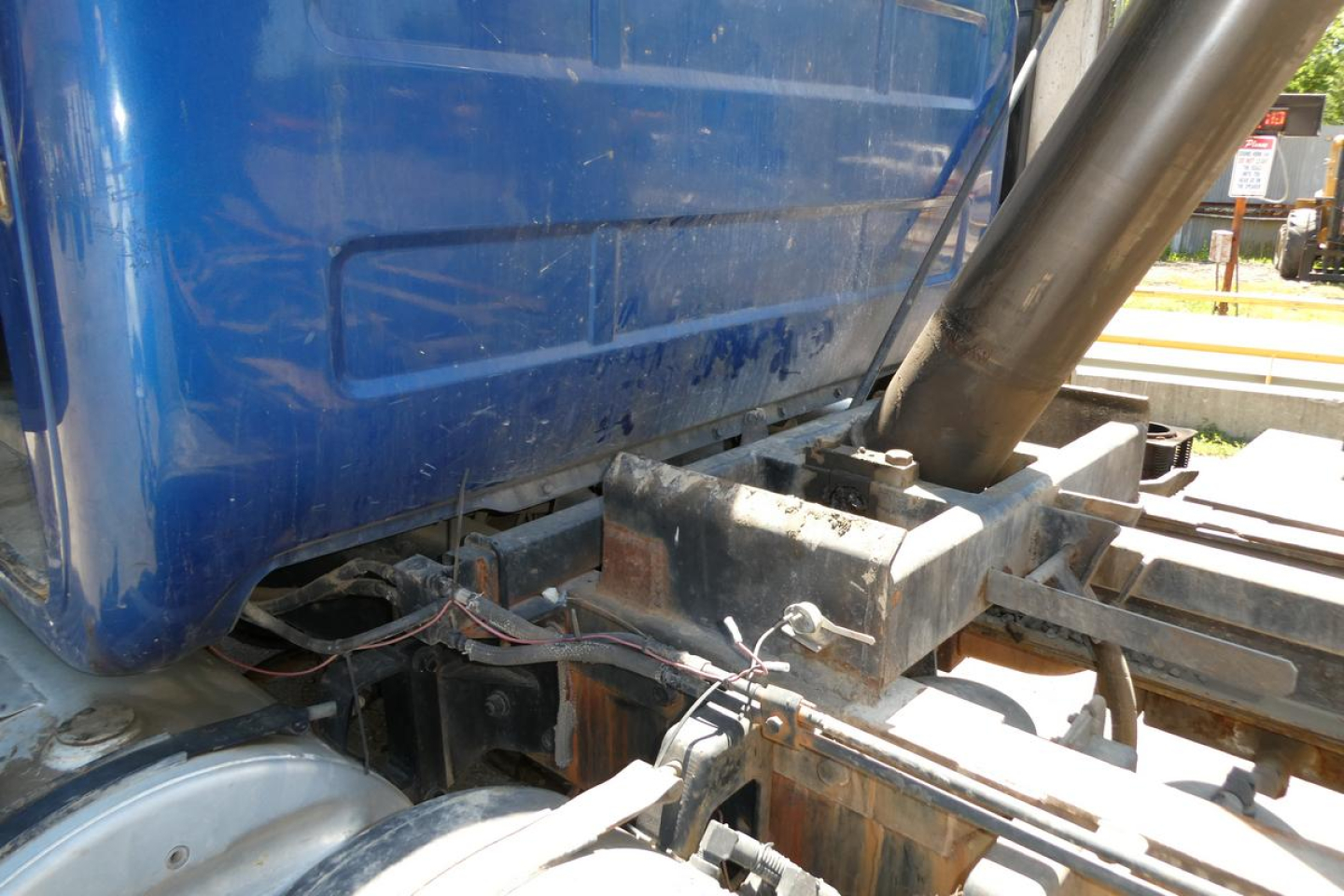 Mack RD688S truck chassis and hydraulic lines with blue cab side and dump bed linkage visible.