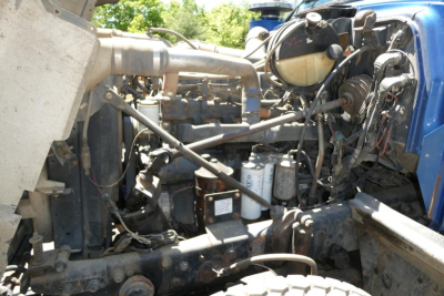 Mack RD688S engine bay showing various hoses, belts, and components including air intake, coolant reservoir, and filters.