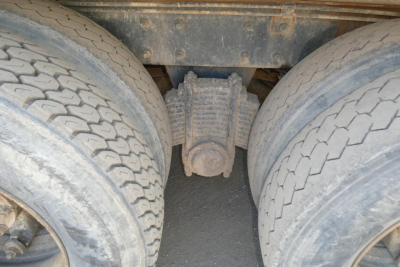 Dual rear tires and a third-axle differential of a Mack RD688S dump truck showing the drivetrain center with a solid axle and differential housing.