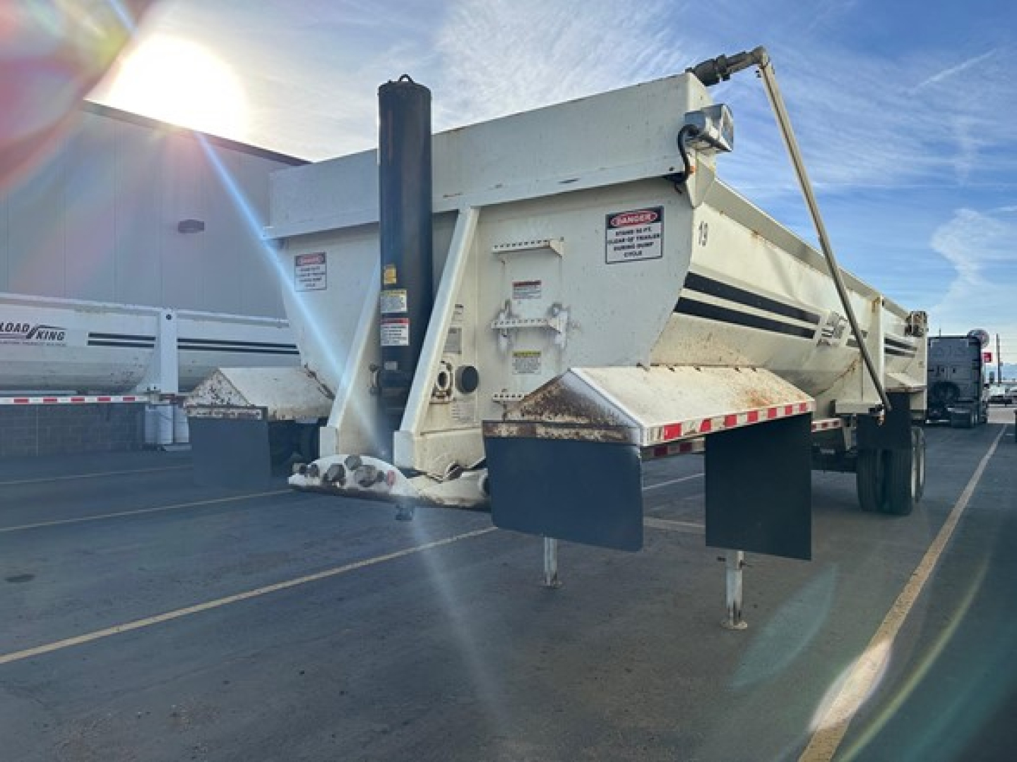 Load King 34' frameless rock end dump trailer in service with front and side views showing tailgate and support legs.