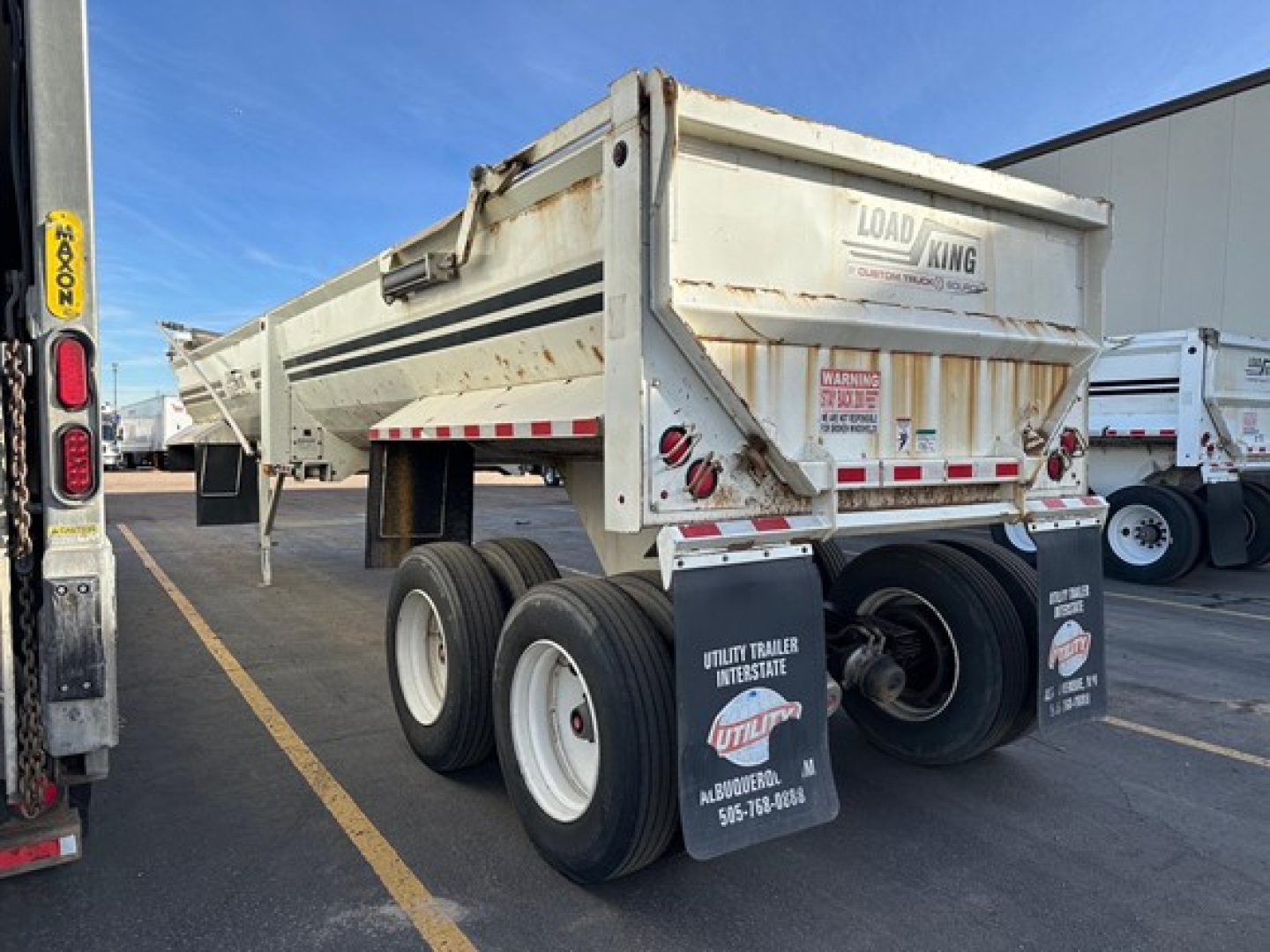Load King frameless rock end dump trailer showing rear dual wheels and tailgate with Load King logo and reflective safety stripes.