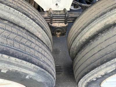 Load King 34' frameless rock end dump trailer showing dual rear axles with dual-tis tires and suspension components.