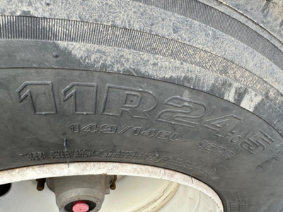 Tire of Load King trailer showing 12.4/4.75 tread and tire markings 149/1460, 16PR, with rim and mud residue.