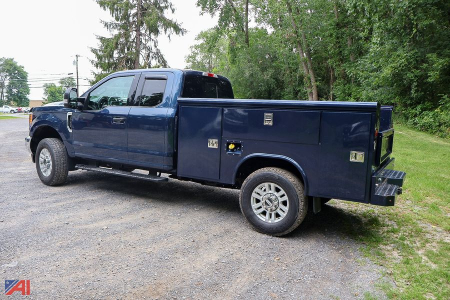 Ford F-350 Super Duty crew cab utility truck with utility bed side compartments, blue exterior, diesel engine, in-service condition.
