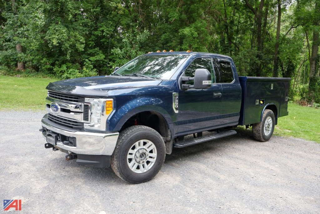 Ford F-350 Super Duty crew cab utility truck in blue, side view, with service bed.