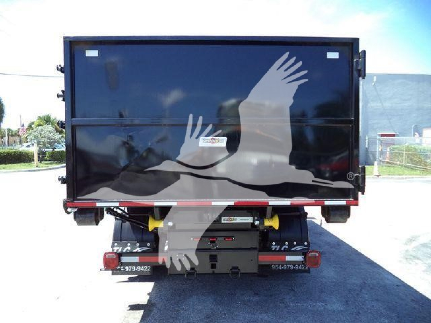 Rear view of a 2023 Chevrolet Silverado 6500HD roll-off truck showing rear cargo bed and hydraulic components.