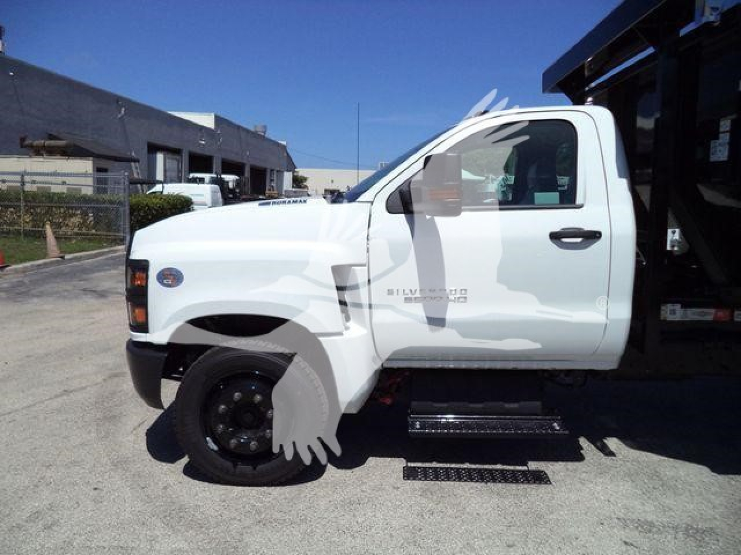 Chevrolet Silverado 6500HD pickup truck side view showing white cab and side steps.