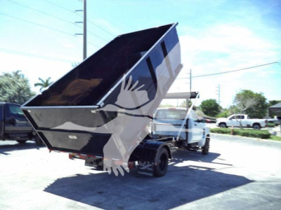 Truck rear view of a 2023 Chevrolet Silverado 6500HD dump bed elevated in rolloff configuration.