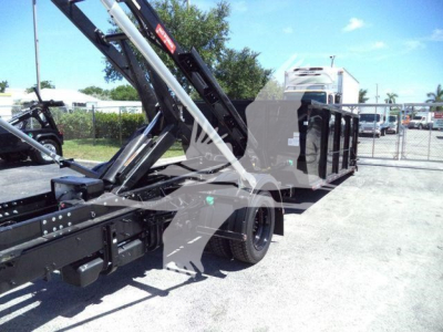 Truck bed and hydraulic arm on a 2023 Chevrolet Silverado 6500HD rolloff configuration showing hydraulic arms and flatbed with side rails.