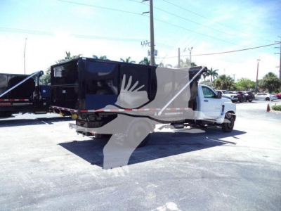 Truck bed body of 2023 Chevrolet Silverado 6500HD rolloff truck showing side view with front cab and cargo container.