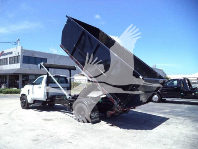 Dump truck bed tilted on a white Chevrolet Silverado 6500HD chassis in a dealership lot.