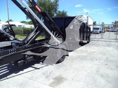 Chevrolet Silverado 6500HD roll-off truck with hydraulic arm and dump bed shown from side.