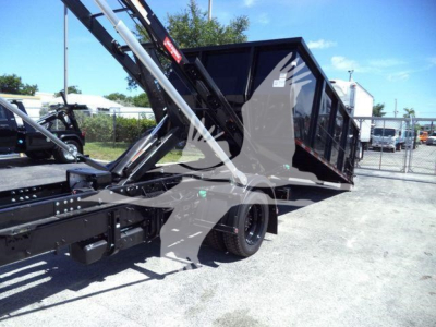 Truck bed with hydraulic tilting mechanism on a Chevrolet Silverado 6500HD roll-off setup showing the cargo bed and lifting arm